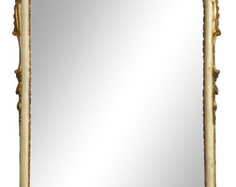 May include: A white and gold ornate mirror with a decorative, scrolled frame. The mirror has a rectangular shape and a beveled edge.