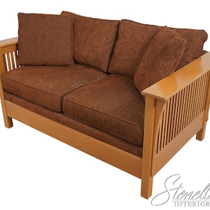 May include: A brown fabric loveseat with a wood frame and slatted back. The loveseat has a simple, traditional design.
