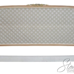 May include: A white and natural wood headboard with a woven cane center. The headboard has a curved top with decorative gold accents. The frame is painted white, and the woven cane is a light beige color.