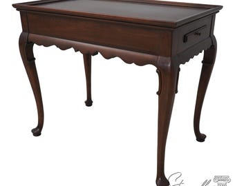 Puede incluir: Una mesa auxiliar de madera marrón oscuro con una tapa rectangular y un solo cajón. La mesa tiene patas curvas y un faldón festoneado. La mesa mide aproximadamente 76 cm de largo, 46 cm de ancho y 71 cm de alto.