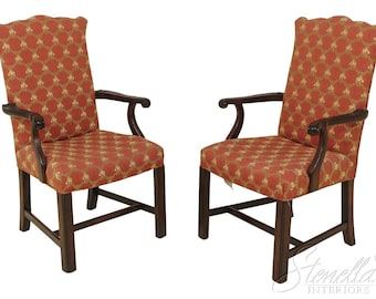 May include: Two wooden armchairs with red and gold patterned upholstery. The chairs have a traditional design with curved arms and a high back.