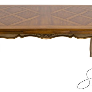 May include: A rectangular wooden dining table with a light brown surface and a decorative inlaid pattern. The table has ornate, curved legs painted in cream with gold accents. The table is a classic piece of furniture.