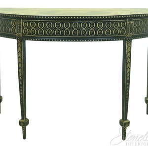 May include: A black and gold painted half-round console table with a decorative pattern on the top and gold accents on the legs.