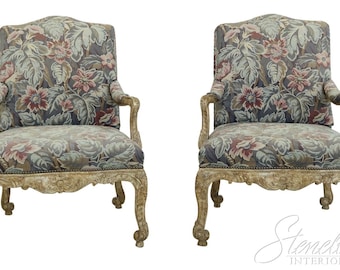 May include: A pair of antique-style armchairs with carved wooden frames and floral upholstery. The chairs are painted in a light, distressed white finish.