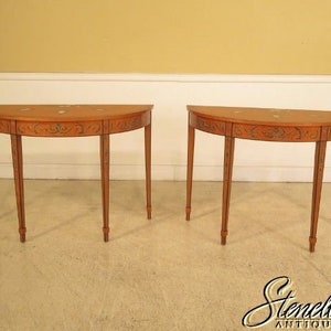 May include: Two matching wooden half-round tables with intricate painted designs and three legs each.