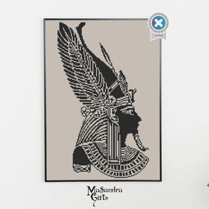 May include: Framed black and white cross-stitch art featuring an Egyptian pharaoh profile with a detailed headdress and beard. The artwork is set against a neutral background and framed in a black border. The artist's name, Masandra Girls, is at the bottom.
