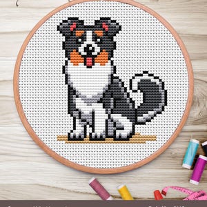 This charming cross-stitch artwork features a playful black and white dog with a cute expression, sticking out its tongue. Encircled by a wooden embroidery hoop, the design is crafted on Aida fabric using DMC thread. Measuring 2.93" x 3.36" with a stitch count of 41 x 47, it incorporates a palette of 7 colors. Surrounded by colorful spools of thread, this piece is perfect for dog lovers and embroidery enthusiasts looking to add a whimsical touch to their collection.