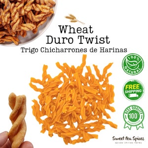 Puede incluir: Primer plano de un montón de trigo duro twist, un tipo de aperitivo crujiente y frito hecho con harina de trigo. El aperitivo tiene forma de torsión y es de color naranja claro. La imagen también incluye el texto "Wheat Duro Twist" y "Trigo Chicharrones de Harinas".