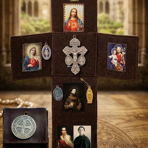 Puede incluir: Un expositor de fieltro marrón en forma de cruz con imágenes religiosas de Jesús, María, José y varios santos. Un crucifijo de plata está centrado, rodeado de pequeñas medallas y alfileres de metal. Se incluye una bolsa de cuero marrón aparte.