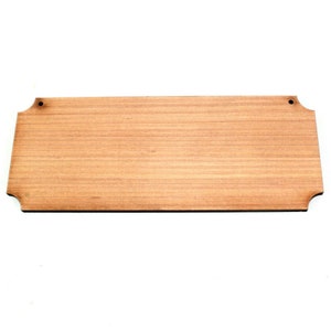 May include: A rectangular wooden sign with rounded corners and two holes for hanging. The sign is made of light brown wood with a natural grain pattern.