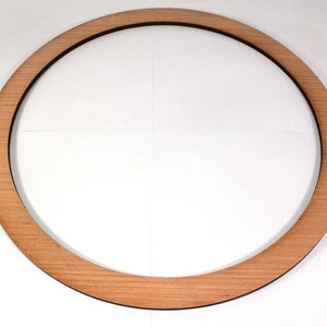 May include: A wooden circle with a black edge, ideal for crafting projects.