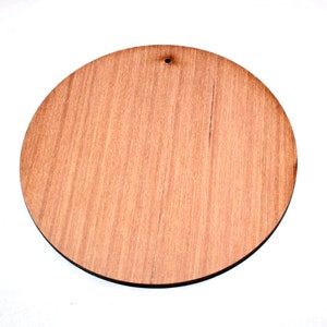 May include: A round, unfinished wooden disc with a hole in the centre. The disc is light brown in colour and has a wood grain pattern.
