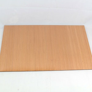 May include: A light brown wood veneer sheet with a smooth surface and a subtle wood grain pattern.