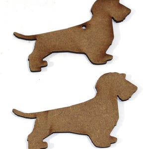 May include: Two brown wooden dachshund dog shapes. The shapes are cut out and ready to be painted or decorated.
