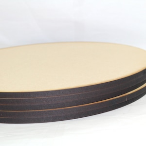 May include: Stack of four round wooden craft blanks with black edges.