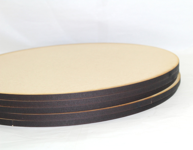 May include: Stack of four round wooden craft blanks with black edges.