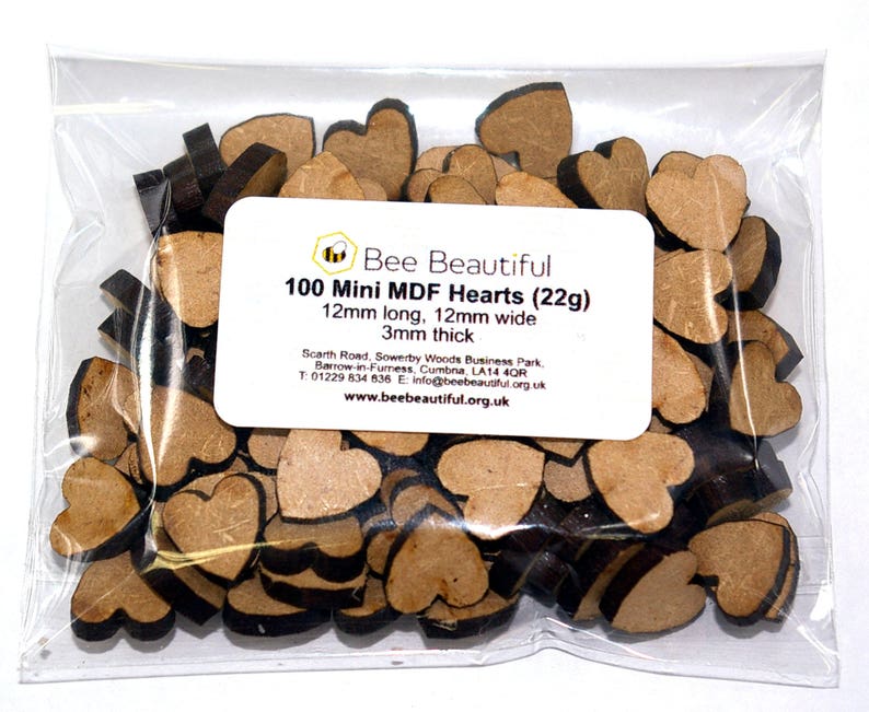 K&ouml;nnte beinhalten: Eine T&uuml;te mit 100 kleinen, braunen Holzh Herzen. Die Herzen sind 12 mm lang, 12 mm breit und 3 mm dick. Die T&uuml;te ist mit "Bee Beautiful 100 Mini MDF Hearts (22g)" beschriftet.