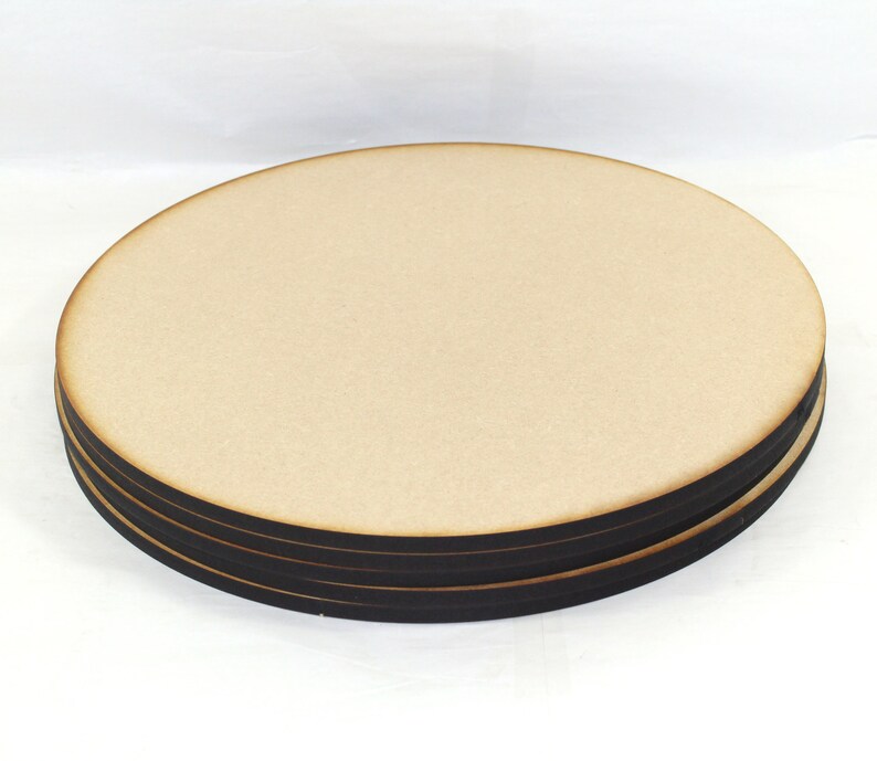 May include: A set of four round wooden coasters with black edges. The coasters are stacked on top of each other.