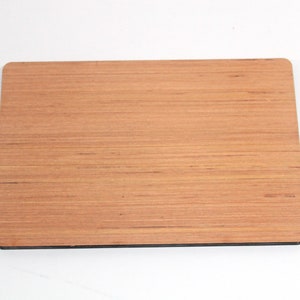 May include: A rectangular wooden sign with a natural wood grain finish. The sign has a dark brown border.