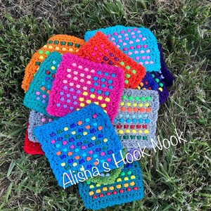 May include: A collection of colorful, crocheted square coasters in various shades of blue, orange, pink, and green. Each coaster features a grid-like pattern with colorful bead accents. The text "Alisha's Hook Nook" is visible.
