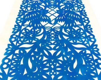May include: A blue paper table runner with a delicate, intricate floral pattern. The design features a repeating motif of flowers and leaves, creating a visually appealing and elegant look.