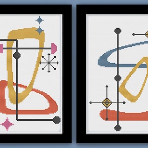 May include: Two framed cross-stitch patterns with a mid-century modern aesthetic. The first pattern features a yellow, orange, and blue abstract design with a black starburst. The second pattern features a blue, orange, and yellow abstract design with a black starburst.