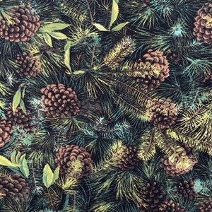 May include: A fabric print featuring brown pinecones and green pine needles on a black background. A wooden ruler is visible at the bottom, showing measurements from 10 to 17 cm, indicating the scale of the repeating botanical pattern.