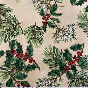 May include: A beige fabric featuring a repeating pattern of green pine needles, dark green holly leaves, clusters of red berries, and white berries. A white selvage edge displays colour circles, numbers 10 through 18, and HOFFMANFABRICS.COM.