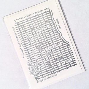 May include: A black and white map of Lower Manhattan, New York City, with street names and compass rose. The map shows the area from West Side and Hudson River to Times Square and Central Park, and from Lower Manhattan to East River.