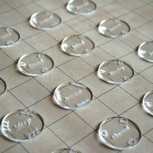 May include: A set of 15 clear plastic tokens with various status conditions written on them, including "Blind", "Charmed", "Deafened", "Dazed", "Restrained", "Paralyzed", "Poisoned", "Prone", "Sleep", "Unconscious", "Grappled", "Incapacitated", "Exhausted", "Bleeding", and "Blinded".