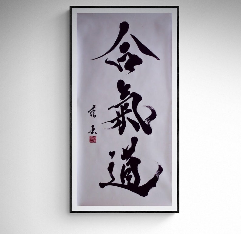 Puede incluir: Caligraf&iacute;a de tinta negra sobre fondo blanco en un marco negro. Los caracteres son "金 鍼 道", que se traduce como "El camino de la aguja de oro".