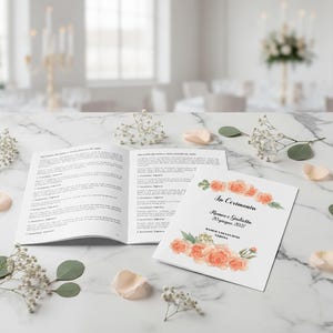 Può includere: Un programma di nozze aperto e un biglietto d'invito con decorazioni floreali. L'invito presenta il testo "La Cerimonia" e i nomi "Romeo e Giulietta" con la data "20 giugno 2022". Il programma aperto mostra testo su entrambe le pagine.