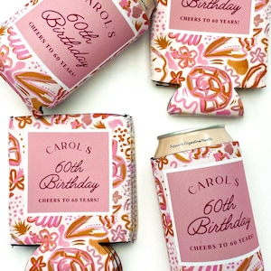 Puede incluir: Cuatro enfriadores de latas con estampado floral rosa y dorado con el texto "CAROL'S 60th Birthday CHEERS TO 60 YEARS!" en cada uno.