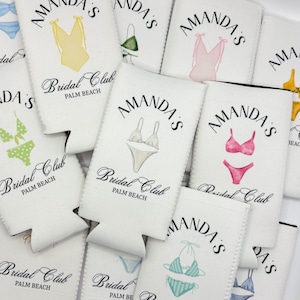 May include: White can coolers with black text and illustrations of swimsuits. The text reads "Amanda's Bridal Club Palm Beach".