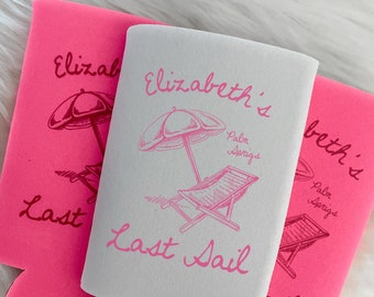 May include: Three beverage insulators. One is white with a pink beach scene and text that reads "Elizabeth's Last Sail Palm Springs." The other two are bright pink with the text "Elizabeth's Last Sail."
