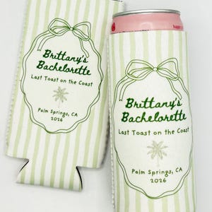 Op de afbeelding: Twee wit en lichtgroen gestreepte blikjeskoelers. Elke koeler heeft een groen strikdesign en de tekst "Brittany's Bachelorette, Last Toast on the Coast, Palm Springs, CA 2026". Eén koeler bevat een roze blikje.