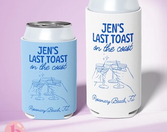 May include: Two white can coolers with blue text and illustrations. The larger cooler says "Jen's Last Toast on the coast Rosemary Beach, FL". The smaller cooler says "Jen's Last Toast on the coast Rosemary Beach, FL".