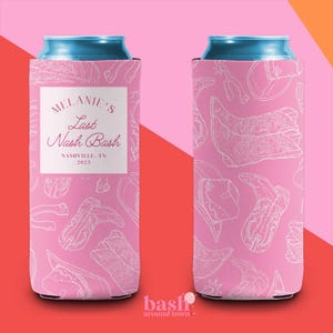 May include: Pink can cooler with a white outline pattern of cowboy boots, spurs, and other Western-themed designs. The front features text that reads "Melanie's Last Nash Bash, Nashville, TN 2025".