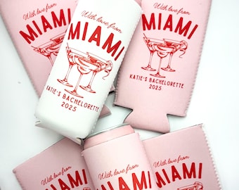 May include: Six pink and white can coolers with the text "With love from Miami" and a cocktail glass graphic. The text "Katie's Bachelorette 2025" is on two of the coolers.