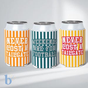 Puede incluir: Tres enfriadores de latas cilíndricos con rayas verticales y texto. El enfriador izquierdo es naranja y blanco con el texto NEVER LOST A TAILGATE. El central es verde azulado y blanco con el texto WEEKENDS ARE FOR FOOTBALL. El derecho es amarillo y blanco con el texto NEVER LOST A TAILGATE.