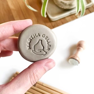 Custom pottery stamp with your name or text and a minimalist base illustrator with a hand. Perfect for fresh clay and leather process stamping.