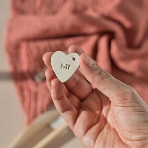 hi! clay stamp stamped on a clay heart shape and a little hold to put a string and use it as a charm by biterswit