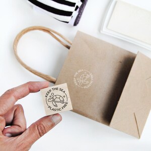 May include: A wooden stamp with a circular design featuring a turtle and the text "Keep the Sea Plastic Free".