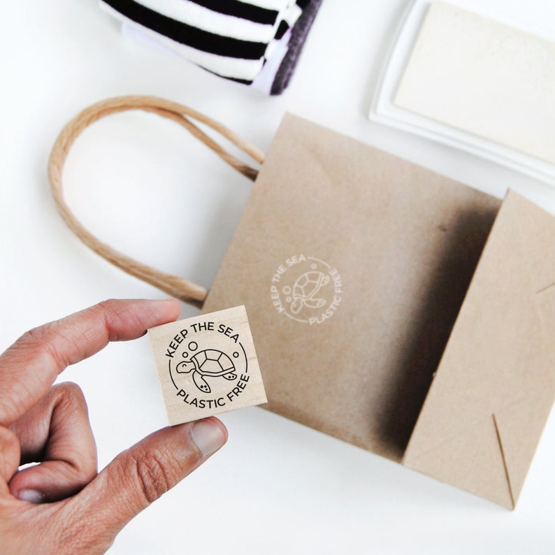 May include: A wooden stamp with a circular design featuring a turtle and the text "Keep the Sea Plastic Free".