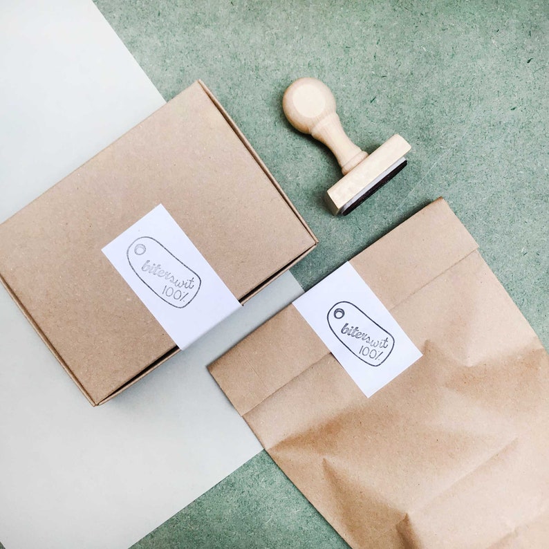 May include: Two brown paper packages with white labels that say "bittersweet 100!" and a wooden rubber stamp with the same text.