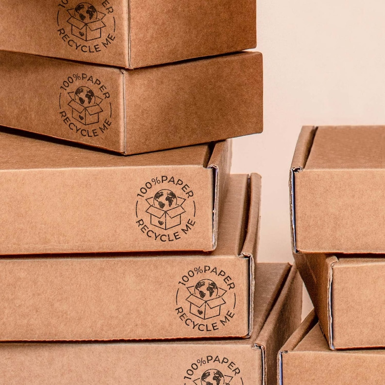 Stacked cardboard boxes with the 100% Paper Recycle stamp printed on the side, showcasing how businesses can mark their shipments with a clear recycling message. The crisp stamped design reinforces eco-friendly branding while ensuring customers recognize the recyclable nature of the packaging. Ideal for sustainable businesses, zero-waste stores, and handmade product sellers.