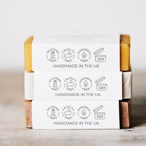 Three artisan soaps stacked with a front view, featuring a soap packaging stamp on the side of the bottom soap. The stamped design is precise, adding a personalized touch to the soap’s natural and handmade aesthetic. Ideal for soap makers looking for an easy, ink-free way to brand their soaps and skincare products with a custom logo stamp.