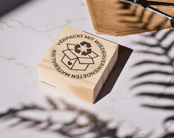 Packed with reused materials stamp in German for sustainable shipping packages, eco packaging, verpackt mit wiederverwendeten materialien