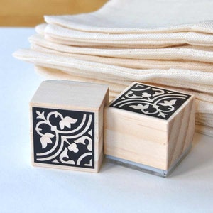 Puede incluir: Dos sellos de madera con dise&ntilde;os florales en blanco y negro. Los sellos son cuadrados y tienen una base de acr&iacute;lico transparente.