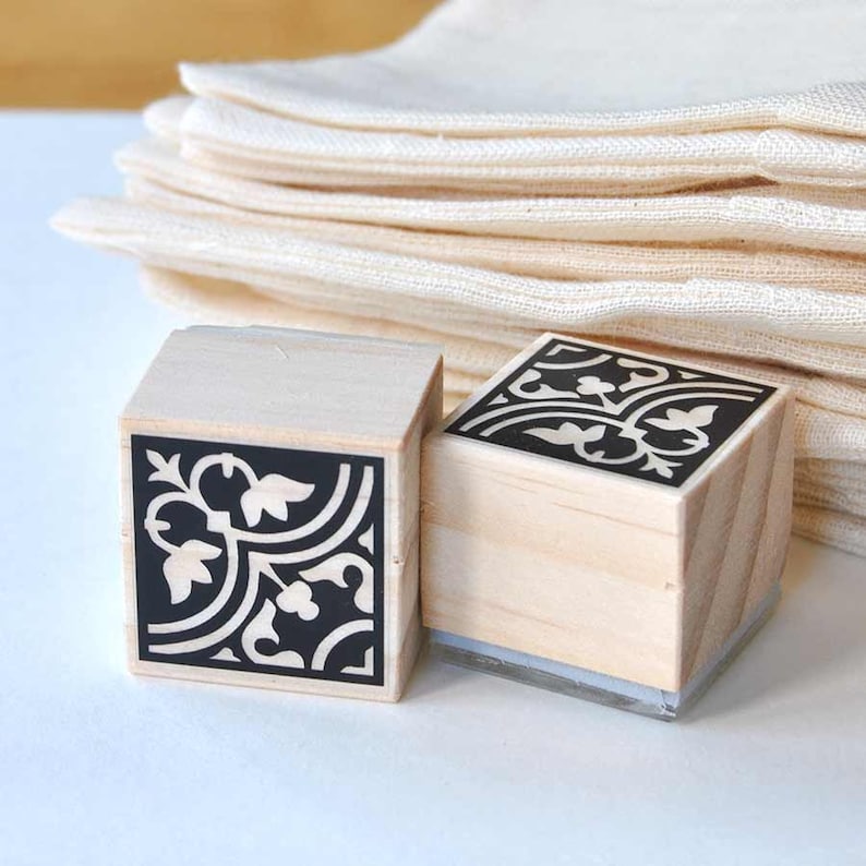 Puede incluir: Dos sellos de madera con dise&ntilde;os florales en blanco y negro. Los sellos son cuadrados y tienen una base de acr&iacute;lico transparente.
